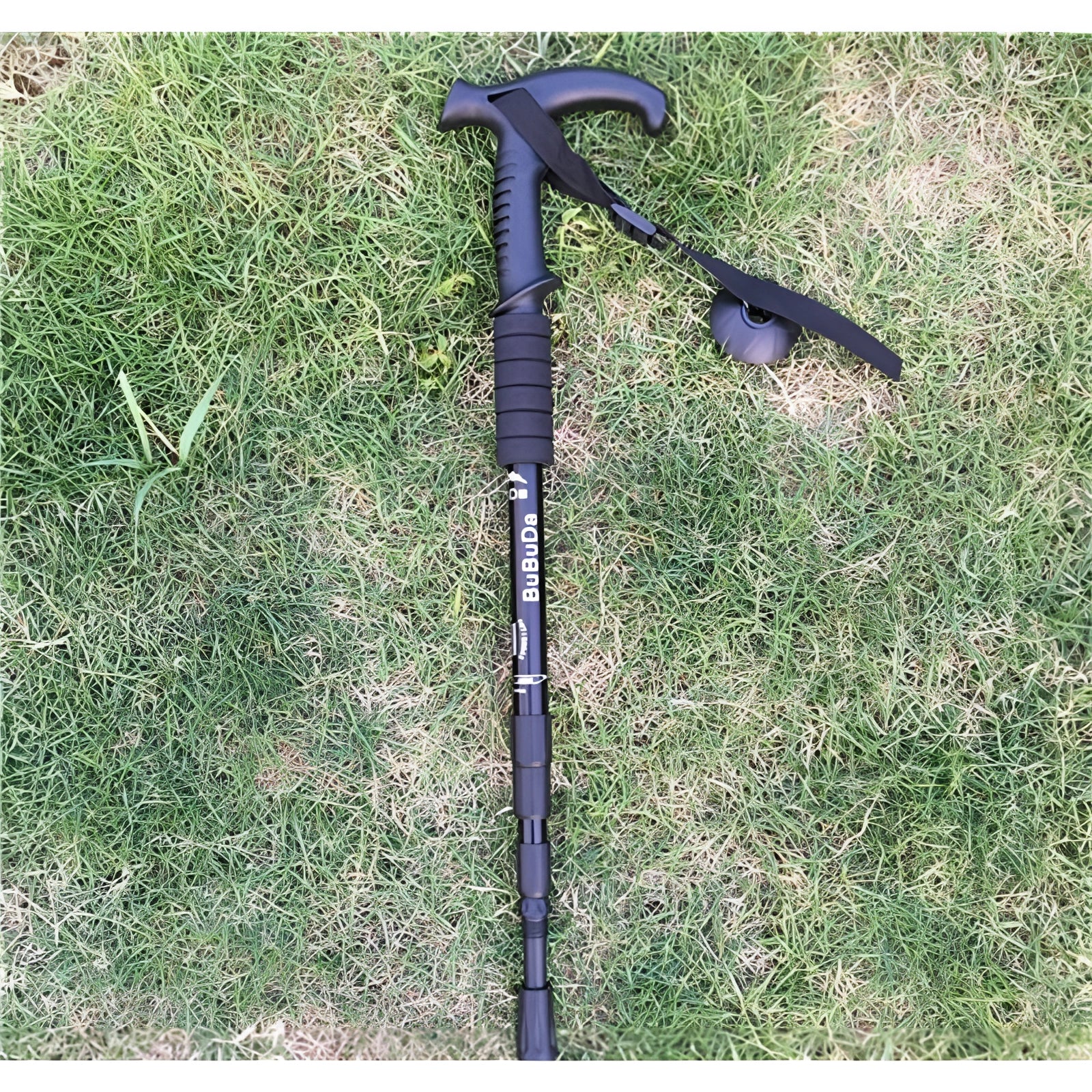 Black L-shaped adjustable shock-absorbing trekking poles, lightweight and ergonomic, standing on grass.