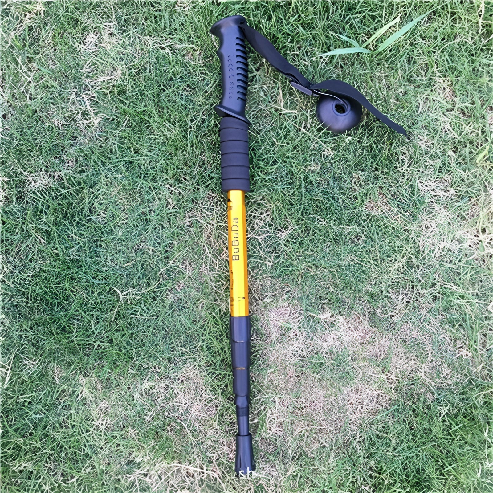 Adjustable shock-absorbing trekking poles, yellow, lightweight, ergonomic, collapsible, displayed on grass.