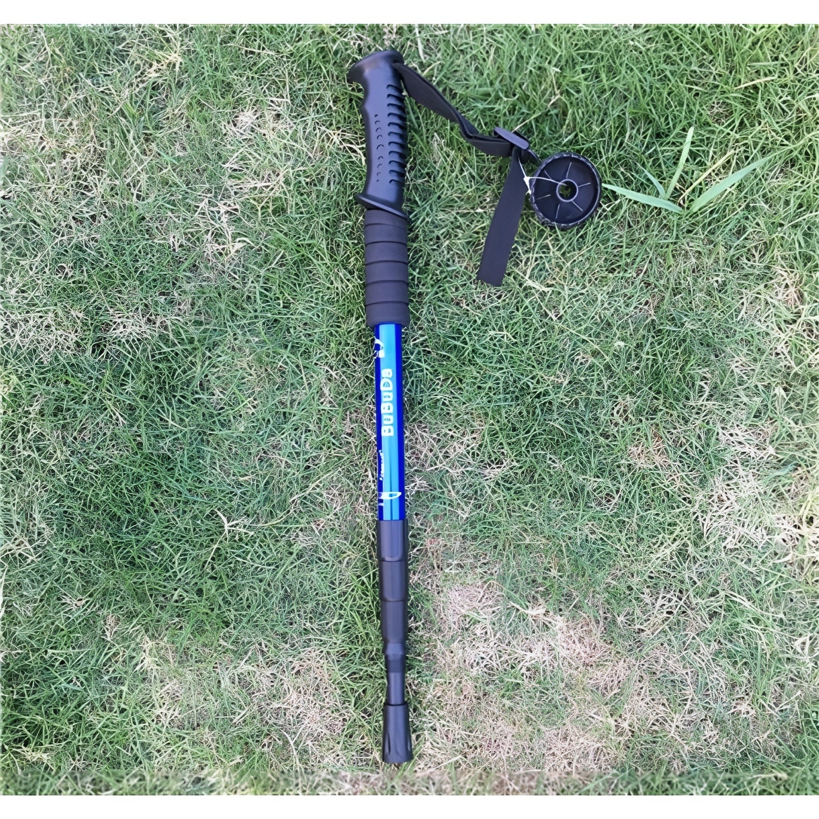 Adjustable shock-absorbing trekking poles in blue with ergonomic grips and collapsible design, standing on grass.