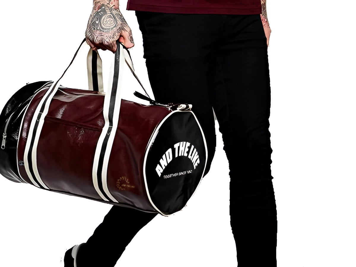 Burgundy leather duffel bag with black accents, designed for men's luxury travel and gym use, showcasing high-quality craftsmanship and ample storage space.