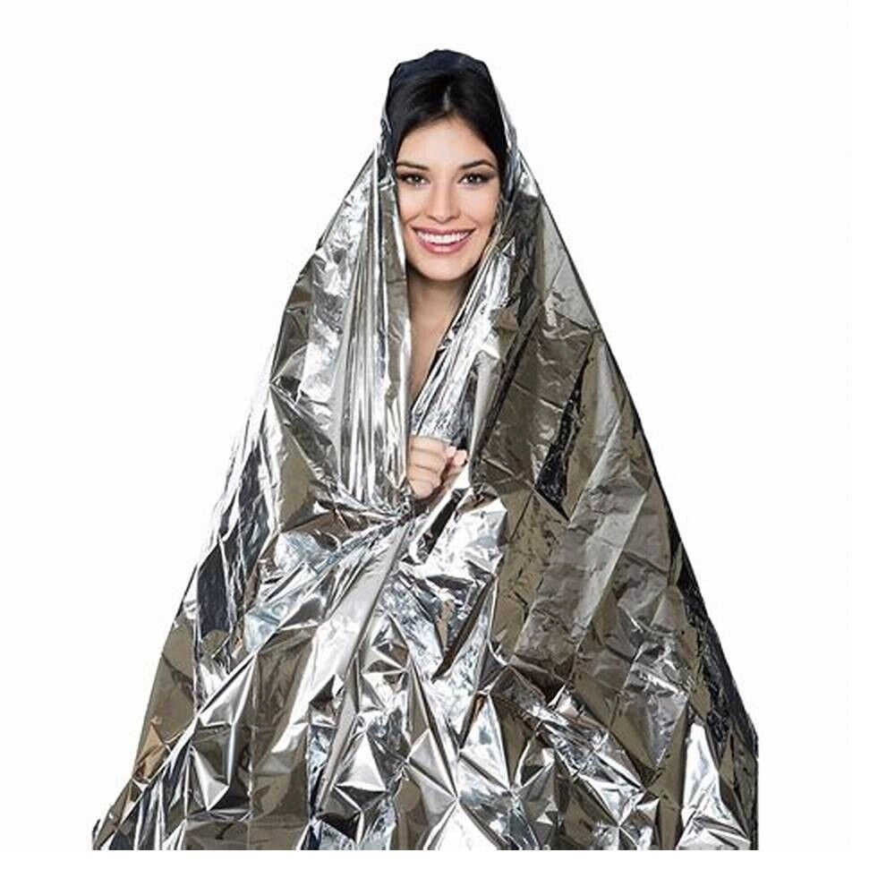 A person smiling while wearing a reflective, heat-retaining mylar emergency thermal blanket over formal wear.