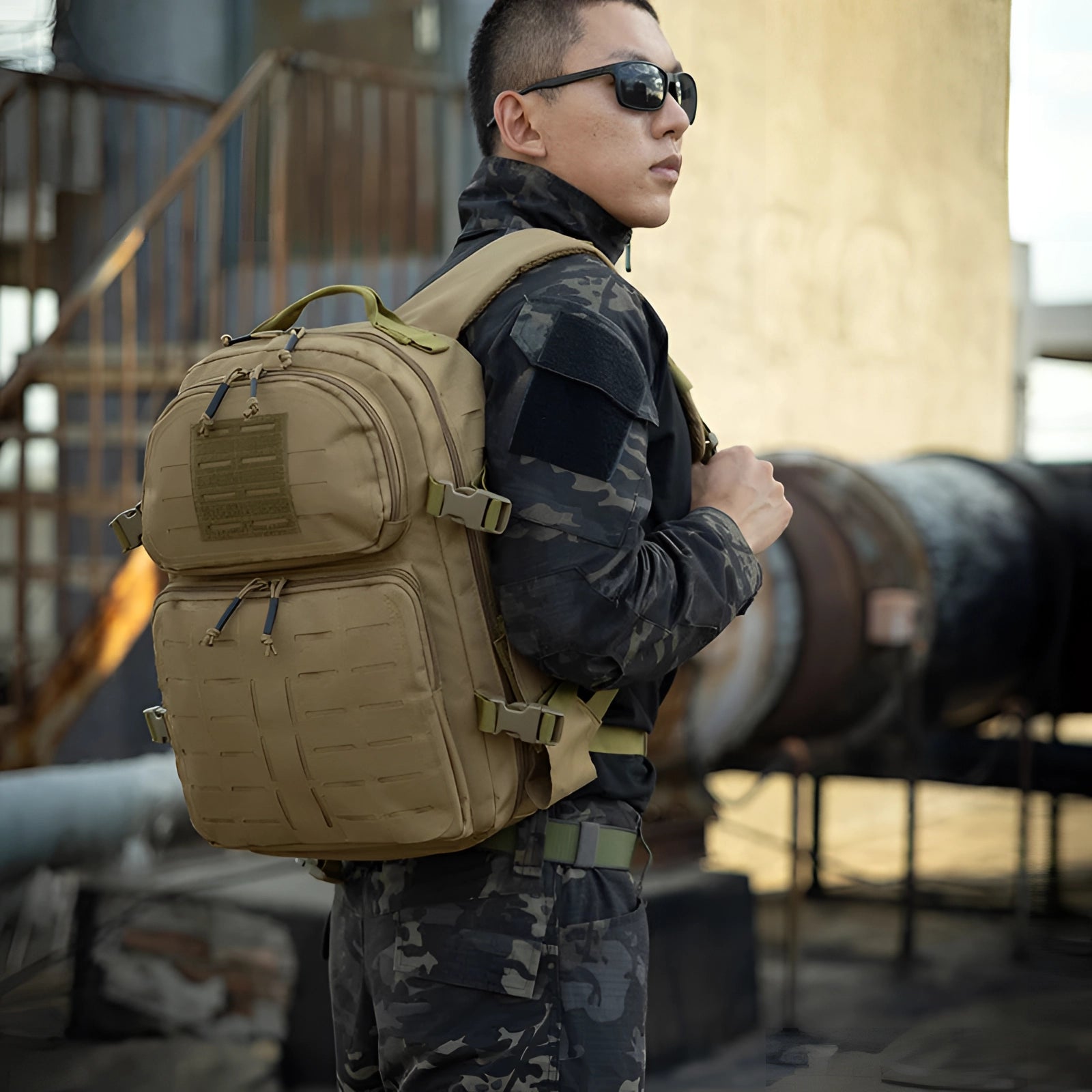 Expandable black MOLLE tactical backpack featuring a durable and water-resistant design, displayed alongside military gear such as camouflage clothing, gloves, and goggles.