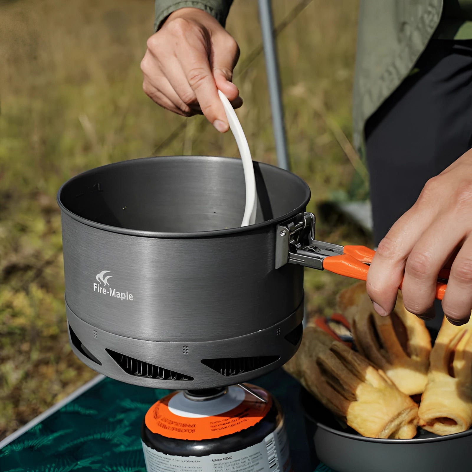 Compact camping cookset made of lightweight anodized aluminum, including cookware designed for outdoor cooking, featuring a small stove for easy food preparation while camping.