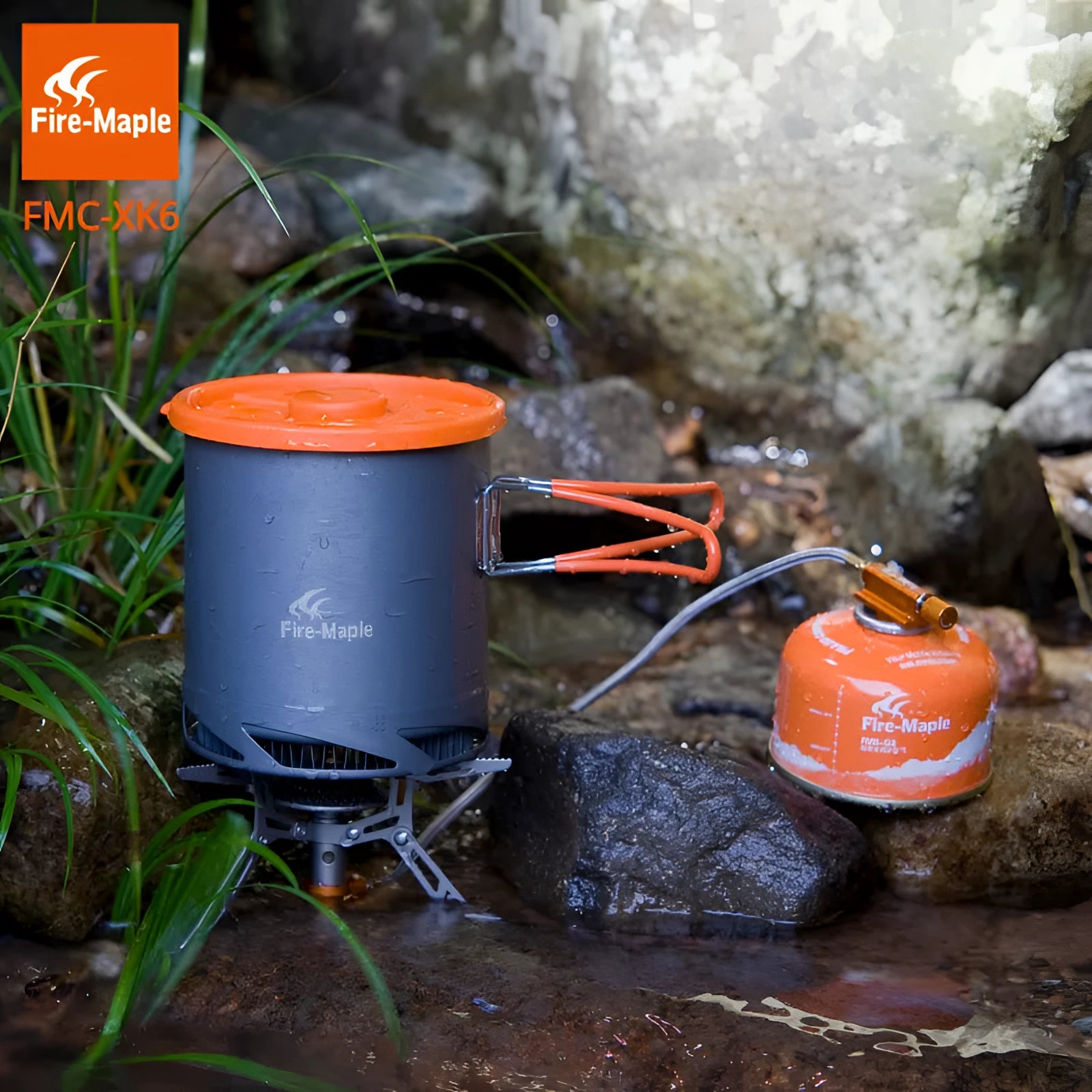 Lightweight Fire-Maple FMC-XK6 camping pot with heat exchanger, featuring a compact cylindrical design suitable for outdoor cooking, surrounded by a natural environment with plants and soil.