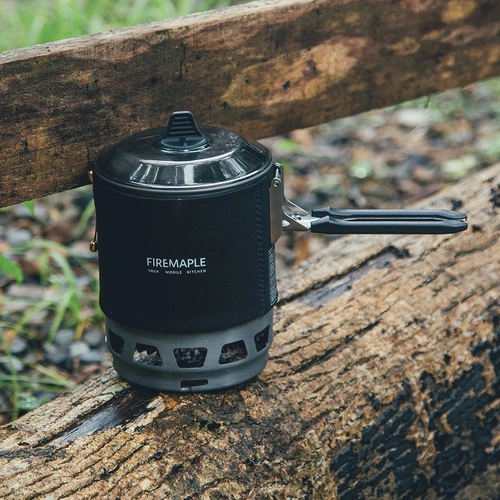 Lightweight windproof camping stove system by Fire-Maple, featuring a cylindrical gas canister and compact design suitable for outdoor cooking.