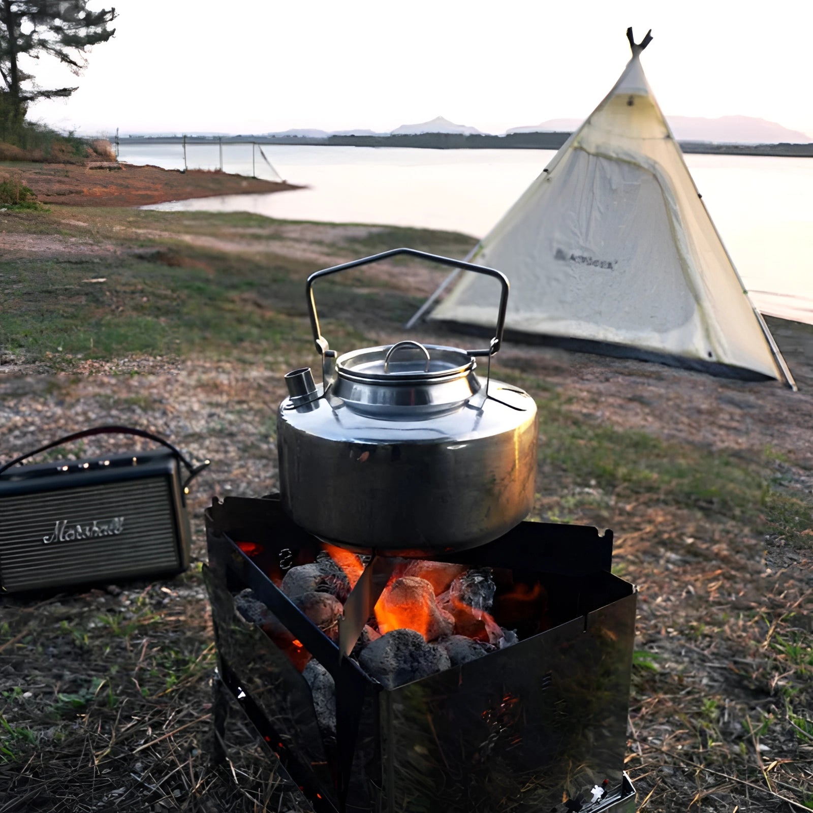 Durable 1L stainless steel camping kettle by Firemaple Antarcti, surrounded by an outdoor camping scene with a tent and cooking setup, highlighting its rugged design suitable for outdoor cooking and boiling water.