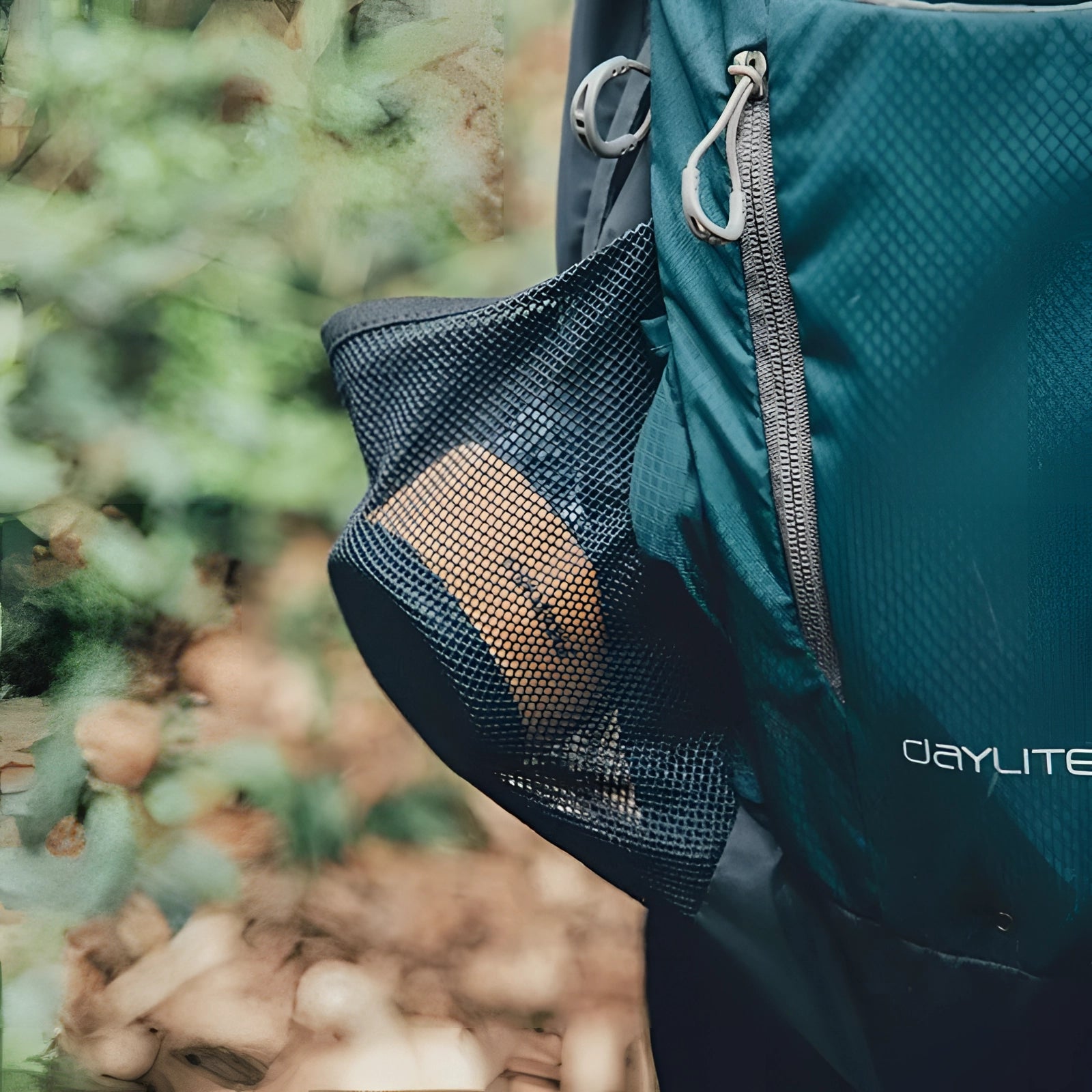 Collapsible silicone travel cup in electric blue, with a sleek design and a 350ml capacity, showcased in an outdoor setting surrounded by trees.