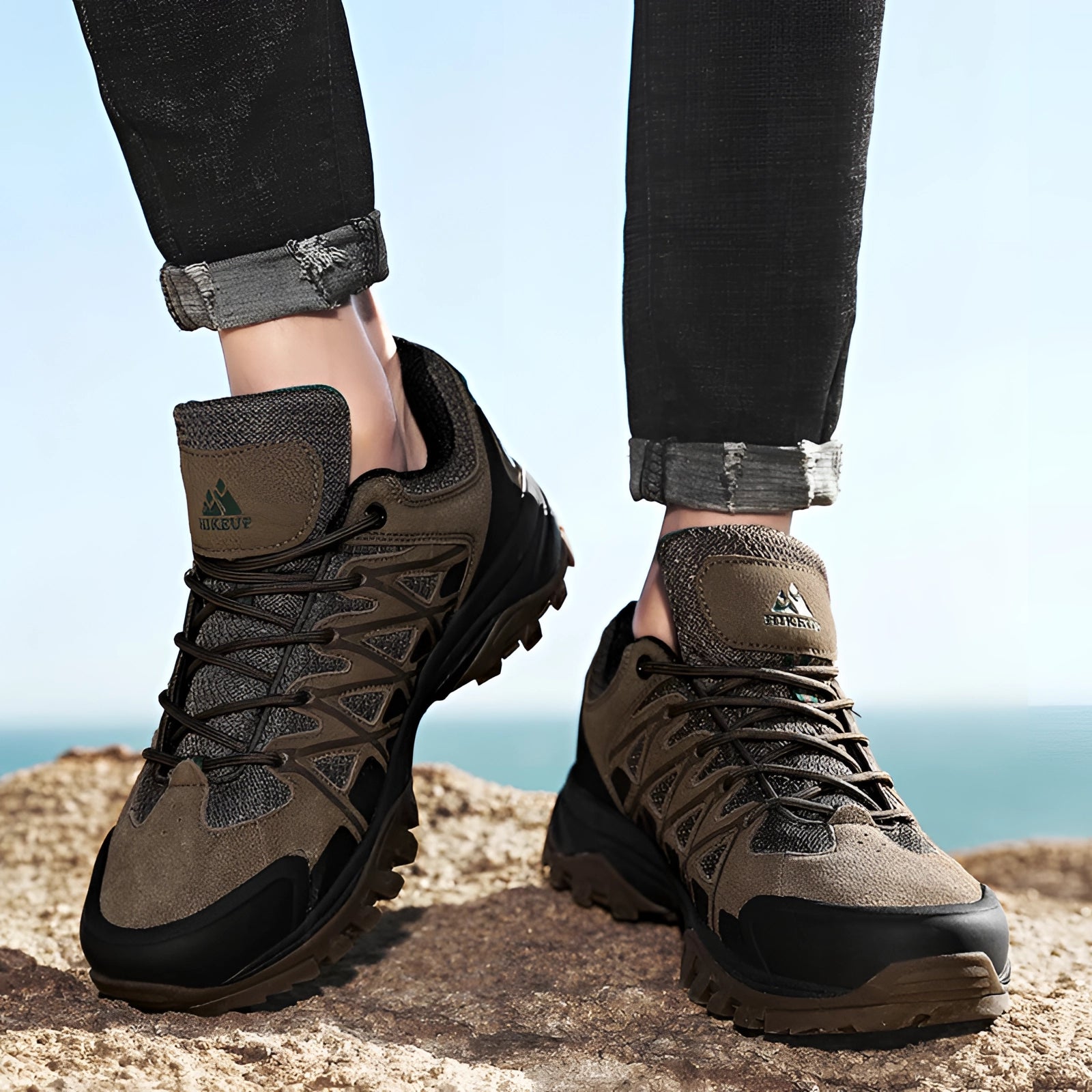 Men's Waterproof Hiking Shoes by HikeUp, shown being worn outdoors with denim jeans against a clear sky backdrop, highlighting their breathable and lightweight design.