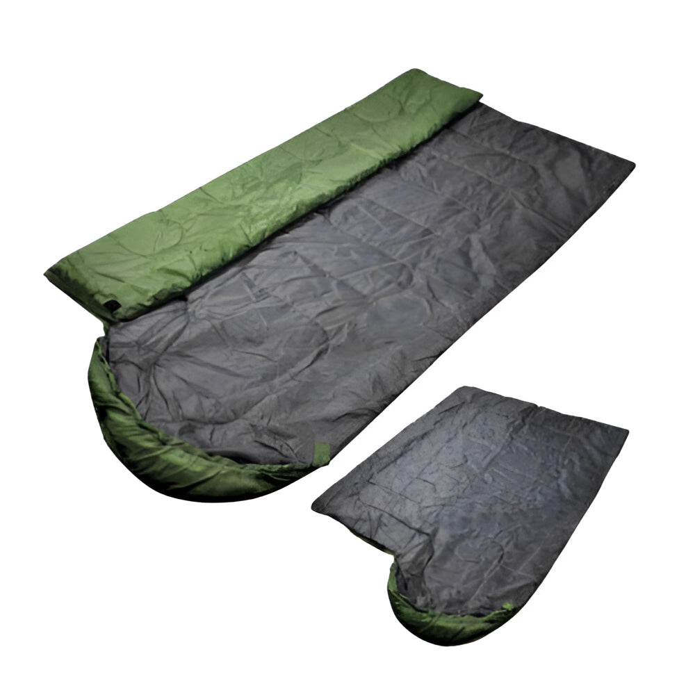 Lightweight all-season water-resistant camping sleeping bag laid on grass with trees and rocks in the background.