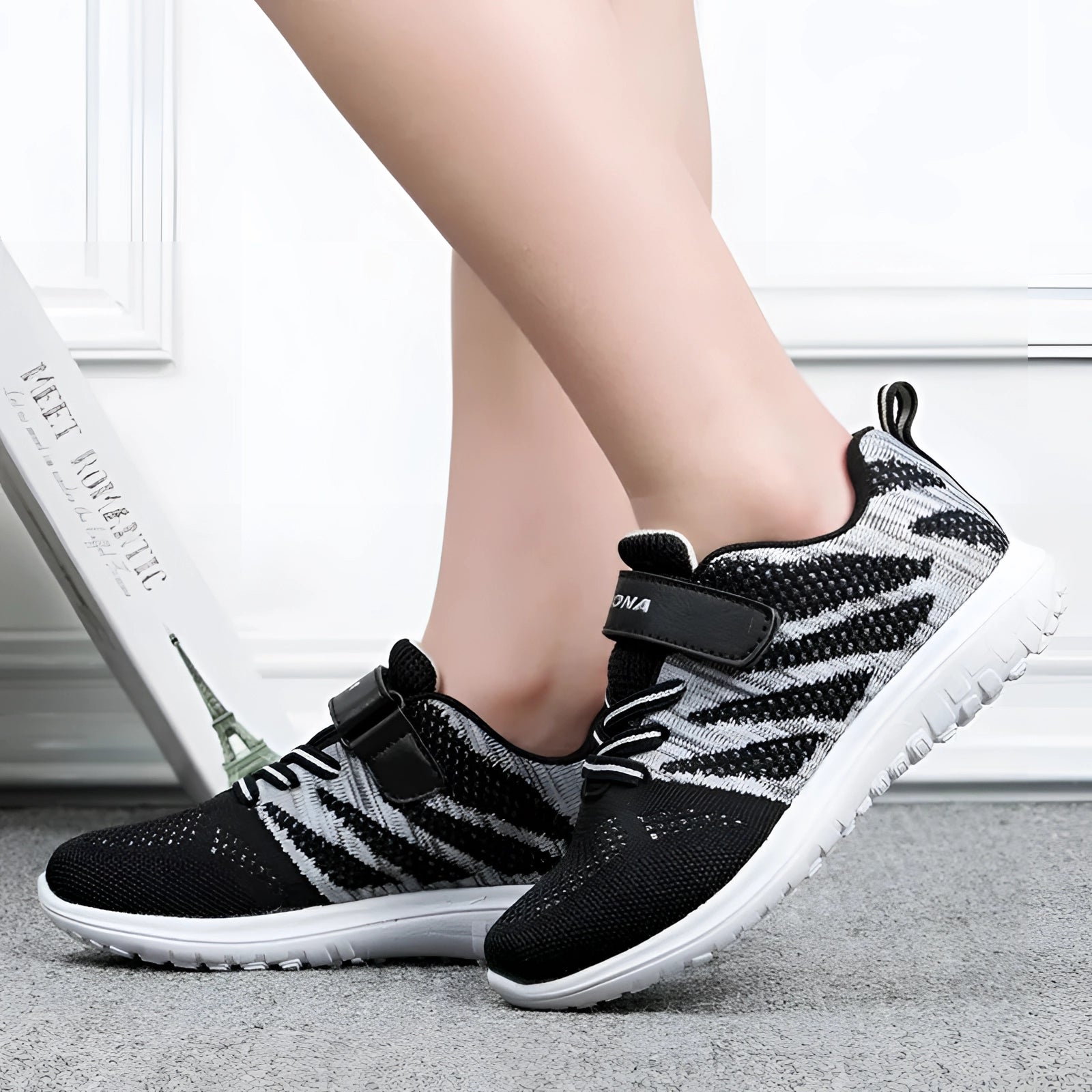 Black and white lightweight unisex breathable Velcro running shoes designed for comfort and style, suitable for walking and sports activities.