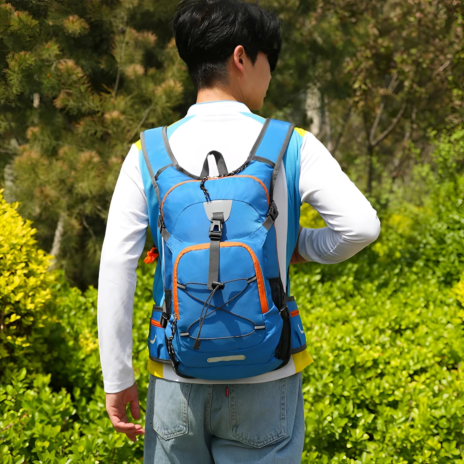 Lightweight water-resistant hiking backpack with a ventilated back, worn by a person in a natural outdoor setting, complemented by a jacket and sportswear.