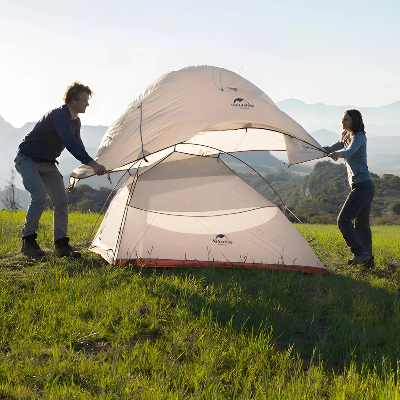 Naturehike Cloud-Up Ultralight 2-Person Waterproof Tent set up on a grassy plain with a clear sky in the background, surrounded by natural landscape and people enjoying outdoor activities.