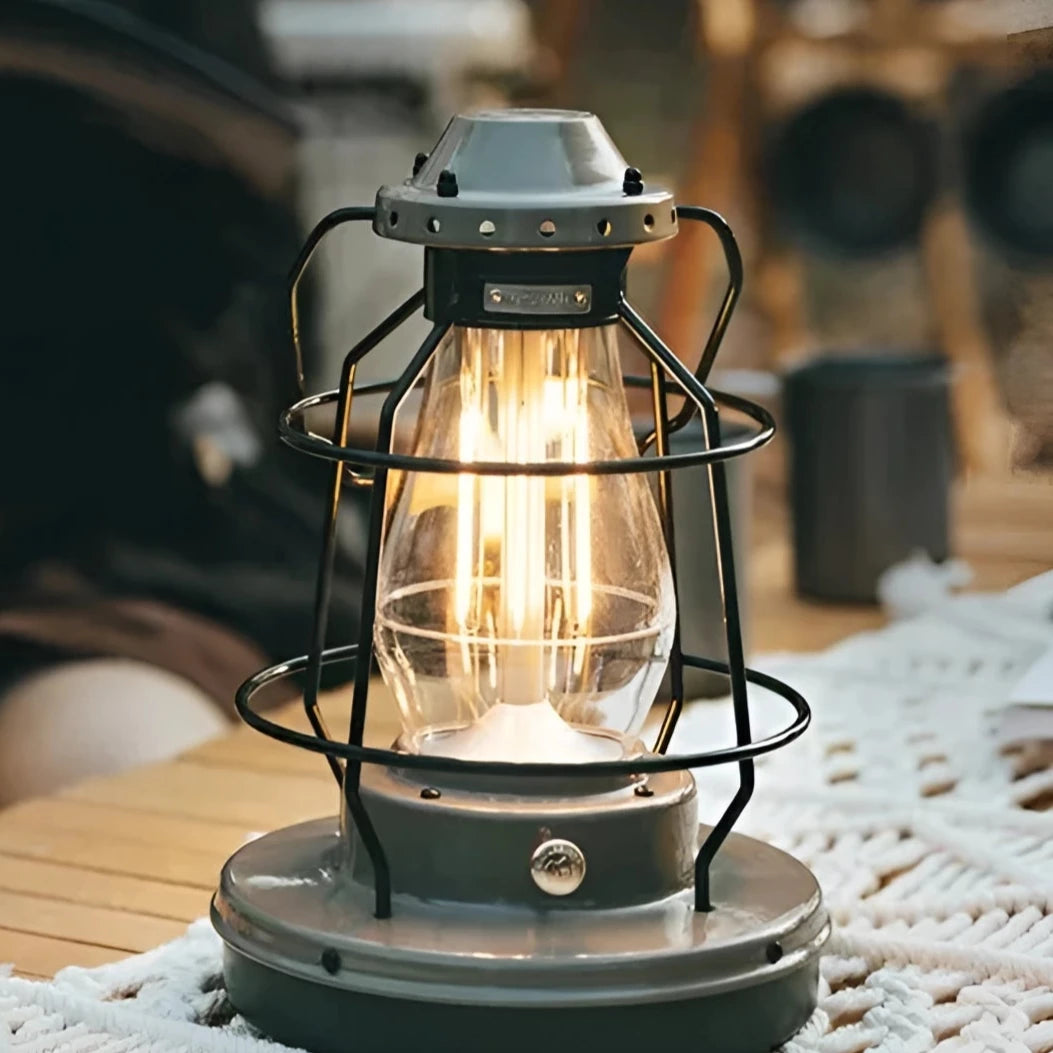 Naturehike Rechargeable LED Camping Lantern placed on a table with drinkware and tableware in an outdoor setting.