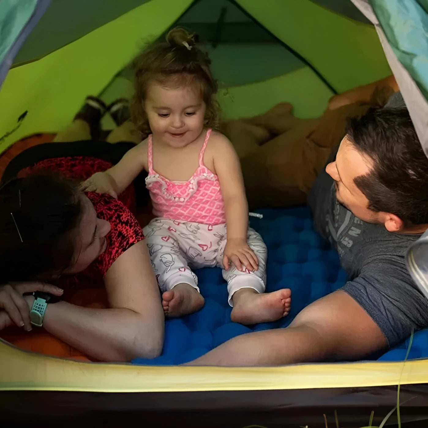 Naturehike Ultralight Inflatable Camping Sleeping Pad inside a tent, person in shorts inflating the pad by mouth, looking happy and comfortable.