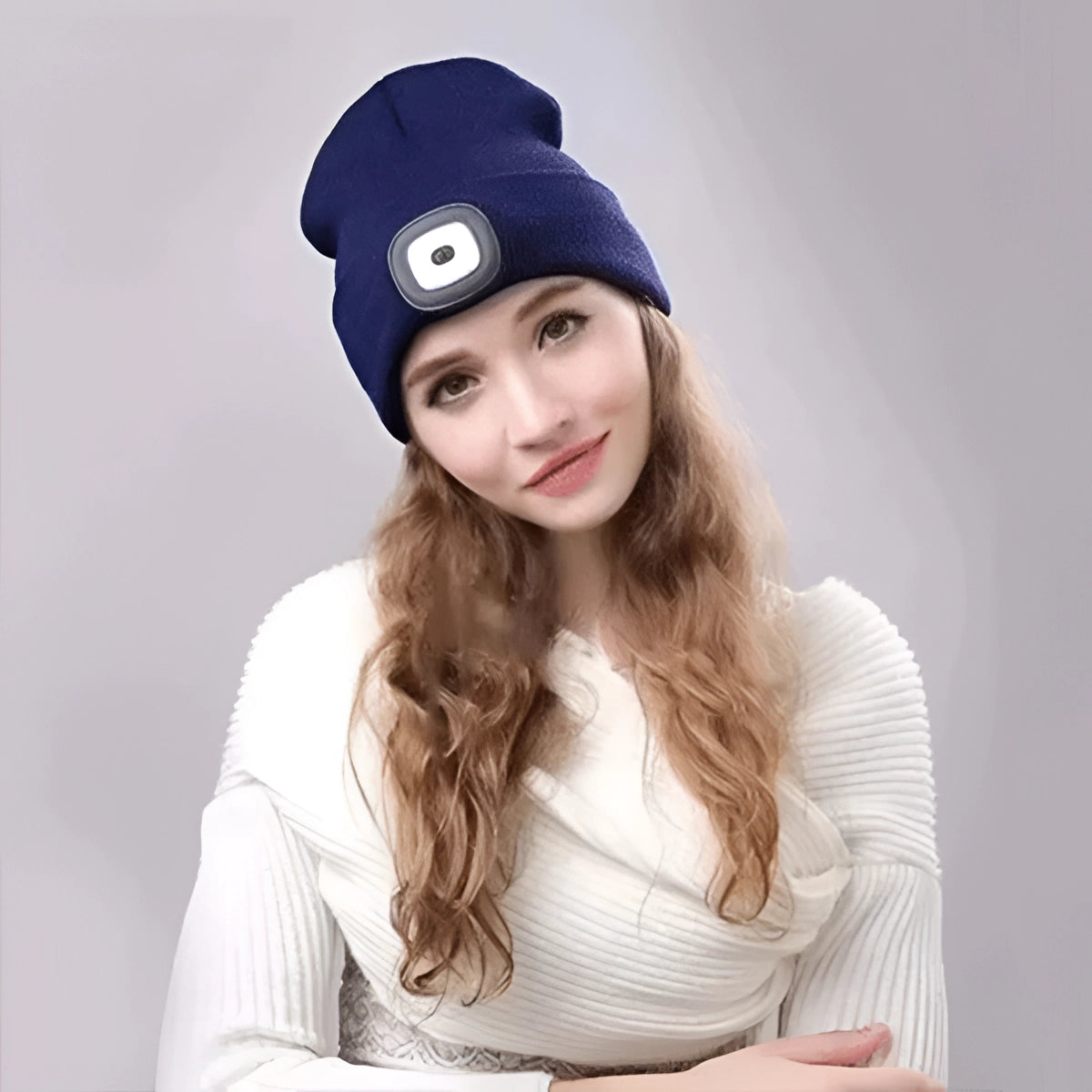 Unisex rechargeable LED beanie hat worn by a smiling person dressed in winter outerwear.