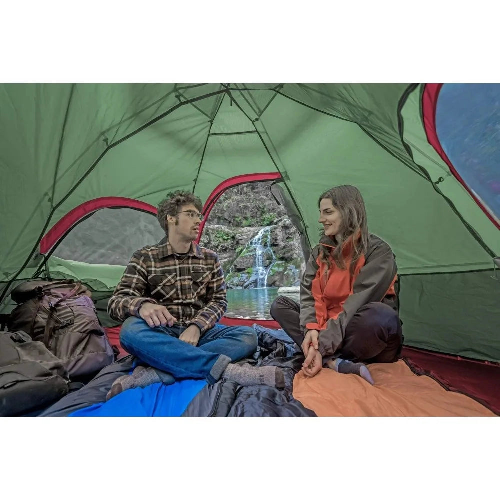 A spacious two-room waterproof family camping tent with dual entrances set up in an outdoor setting, featuring people dressed in outerwear, showcasing its easy setup and comfortable design for leisure and recreation.