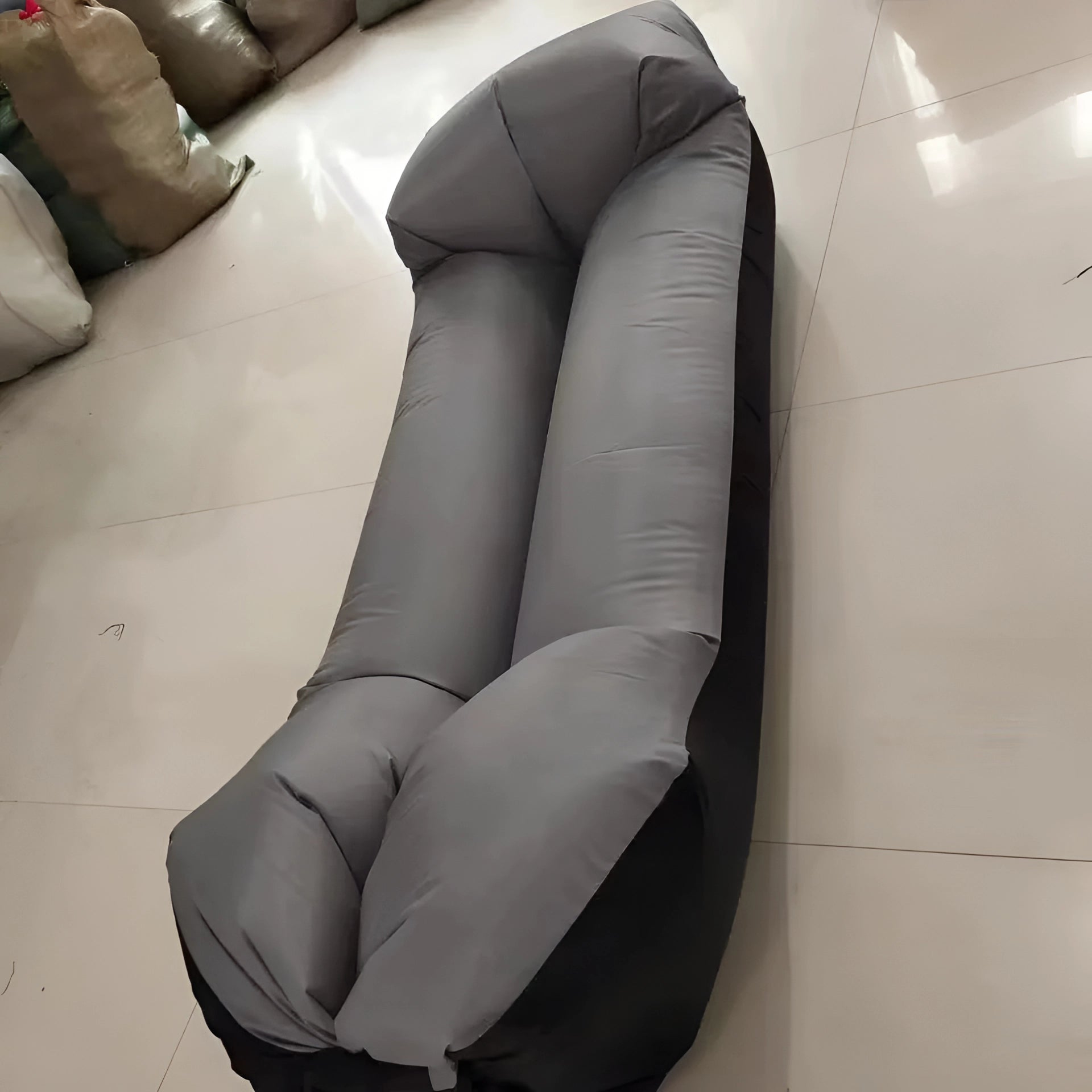 Gray Waterproof Outdoor Inflatable Sofa, shown inflated and set up on a floor, highlighting its couch-like design and comfort for recreational use.