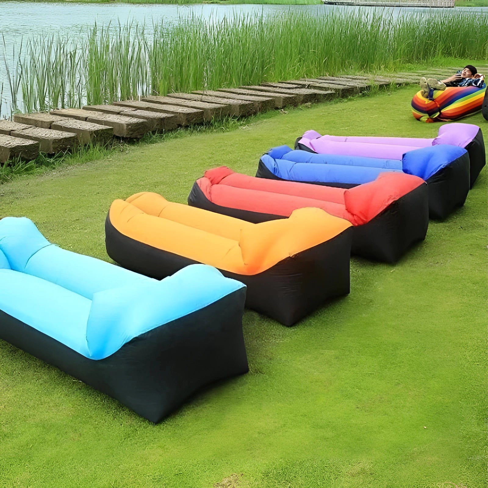 Waterproof green inflatable outdoor sofa set up on grass near water.