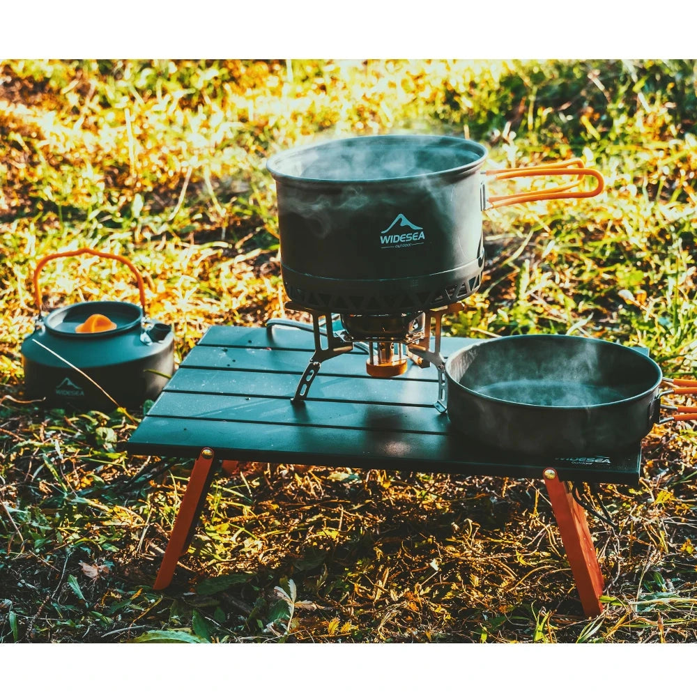 Lightweight and compact WIDESEA portable aluminum camping table set up on grass, ideal for outdoor cooking and dining activities.