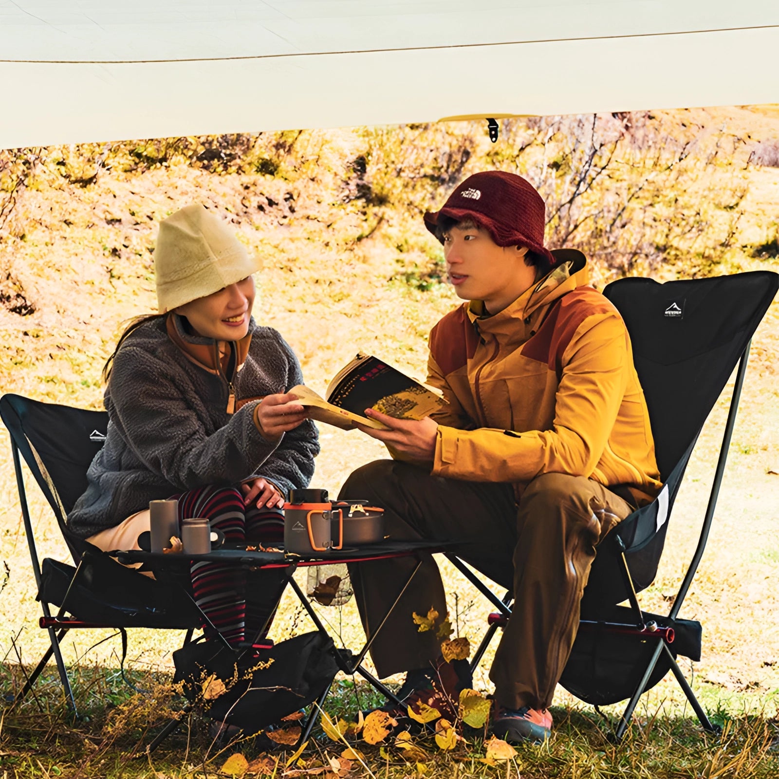 A lightweight, ultralight folding camping chair with a portable mesh seat set up on grass in a natural outdoor setting, ideal for leisure and recreation.